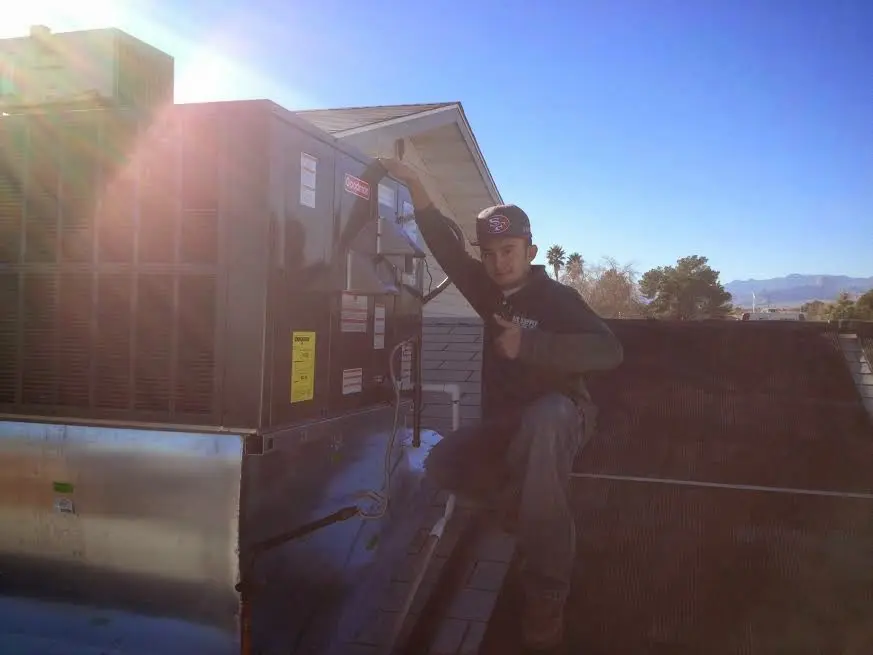 HVAC technician performing Air Duct Cleaning on a rooftop unit in Conshohocken
